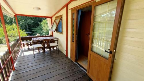 een houten veranda met een tafel en een houten deur bij la casetta da paola in Bardalone