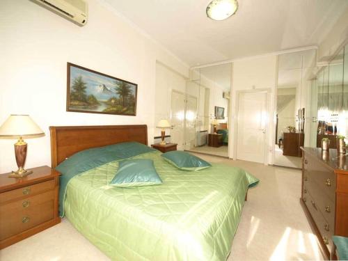 a bedroom with a green bed with two pillows at Patatas Villa in Limassol