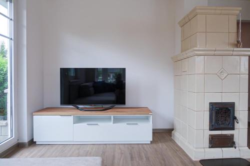 una sala de estar con TV en un centro de entretenimiento blanco en Pannonia Lake House, en Neusiedl am See