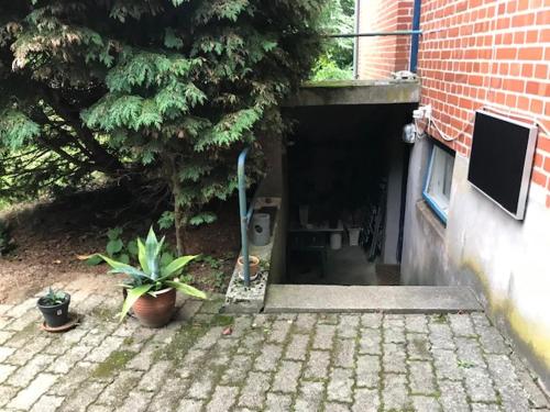a garage entrance to a brick building with a tree at Glyngøre Bed & Breakfast in Glyngøre