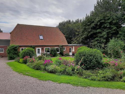 una casa con un jardín delante de ella en Landhof Osterdeich, en Emmelsbüll-Horsbüll