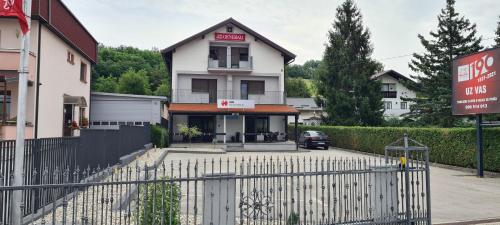 a white house with a gate in front of it at Apartman Max 2 in Biškupec Zelinski