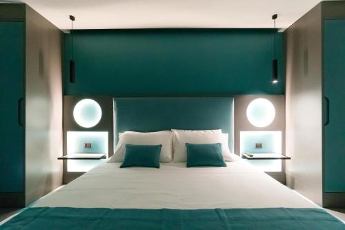 a large bed with a green headboard and two pillows at Akyra suites in Sorrento