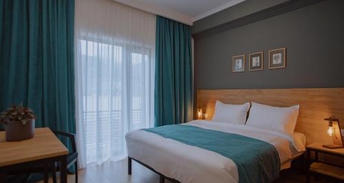 1 dormitorio con cama, escritorio y ventana en Northgate Hotel Kazbegi en Kazbegi