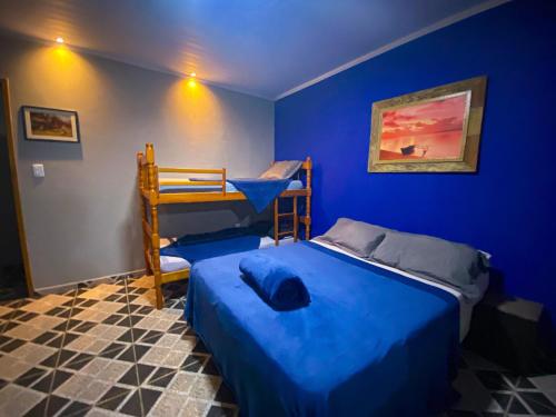 a blue bedroom with a bed and bunk beds at Casa Luke Paraty - Praia e cachoeira in Paraty