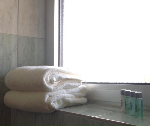 un montón de toallas sentadas en un mostrador en un baño en Lanthotellet Hishult en Hishult