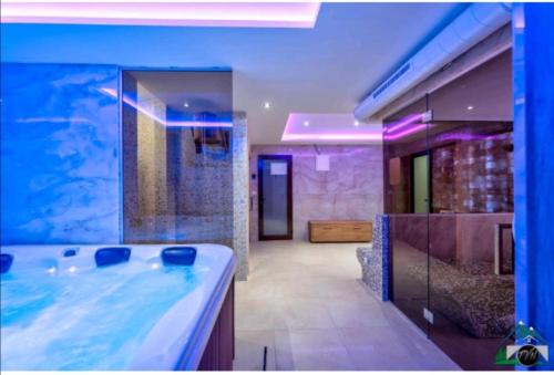 La salle de bains est pourvue d'un lavabo et d'un grand aquarium. dans l'établissement Zlatibor Apartman & Spa Casa Perfetta, à Zlatibor