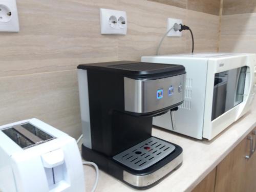 a coffee machine sitting on a counter next to a microwave at DOBRA RAKIJA - transit sleep in Dobra