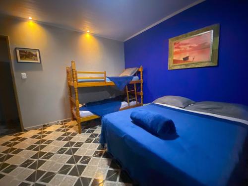 a blue bedroom with two beds and a bunk bed at Casa Luke Paraty - Praia e cachoeira in Paraty