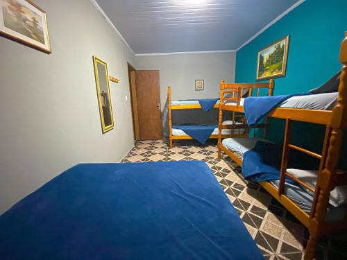 a room with two bunk beds and blue walls at Casa Luke Paraty - Praia e cachoeira in Paraty