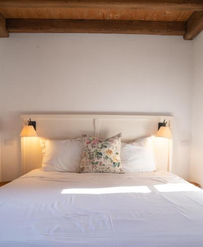 a white bed with two pillows and two lamps at Agriturismo Il Sarale - Umbria in Città di Castello