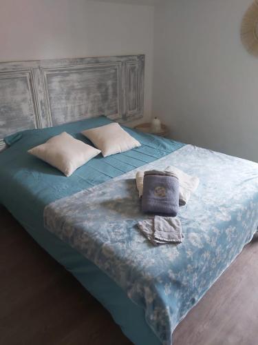 - un lit avec une couette bleue et une serviette dans l'établissement Charmante maison basque. Idéale famille & enfants, à Anhaux