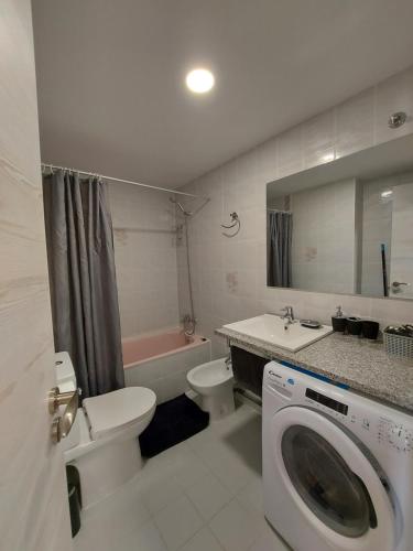 y baño con lavamanos y lavadora. en Viva Sky Benidorm, en Benidorm