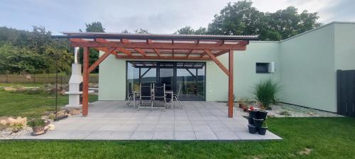 a pergola with chairs and tables on a patio at Panorama house Brdy in Příbram