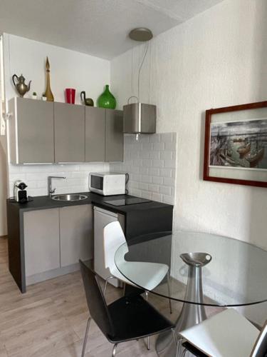 a kitchen with a glass table and a chair at Apartment on Dante street next to the sea in Nice