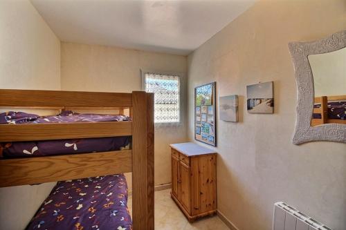 une chambre avec deux lits superposés et une fenêtre dans l'établissement Appartement à 50 mètres de la mer - Les embruns, à Berck-sur-Mer
