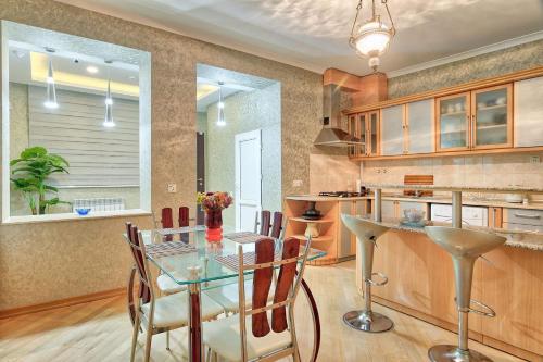 a kitchen with a glass table and some chairs at Q&B House in Tbilisi City