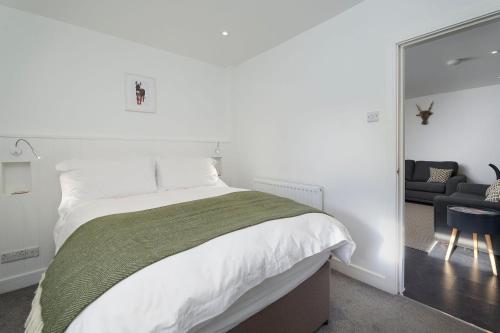 a bedroom with a large bed and a mirror at The Stable - The Cottages at Blackadon Farm in Ivybridge