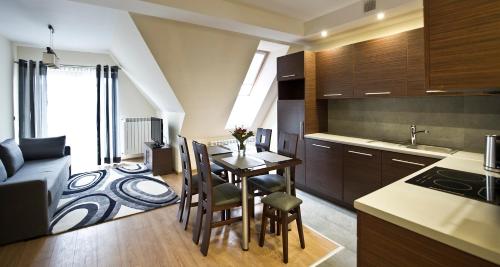 a kitchen and living room with a table and chairs at Apartamenty Viva Tatry in Zakopane
