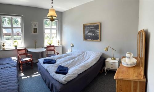 una camera con letto, tavolo e sedie di Store Stensig (landlig idyl ved Frederikshavn) a Frederikshavn
