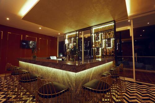 a bar in a restaurant with chairs around it at Number One Oxford Street Hotel & Suites in Accra