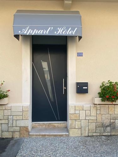 une porte d'entrée d'un hôtel munie d'un panneau. dans l'établissement Appart’hôtel les perles du lac, à Tombeboeuf