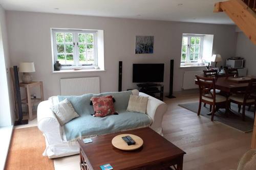 a living room with a couch and a table at Characterful Cottage adjacent to an Orchard in Brockley