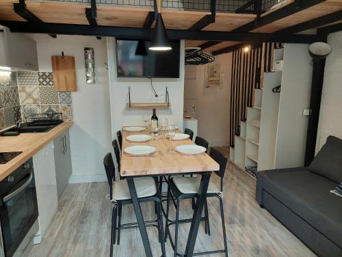 une table de salle à manger avec des chaises et une cuisine dans l'établissement Appartement mezzanine 6 personnes avec balcon vue sur la montagne, à Cauterets