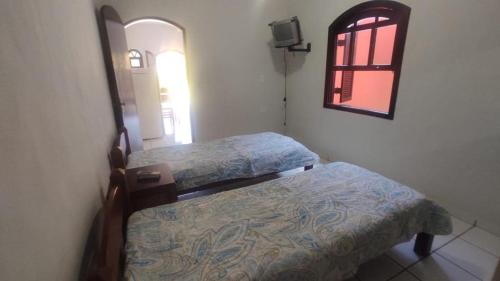 1 Schlafzimmer mit 2 Einzelbetten und einem Spiegel in der Unterkunft Chalé Aconchegante in Ilhabela