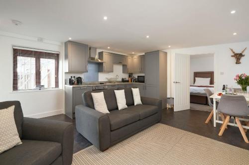 a living room with a couch and a kitchen at The Loft - The Cottages at Blackadon Farm in Ivybridge