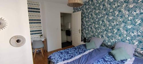 a bedroom with a bed and a blue and white wall at Le Wellington in Arras