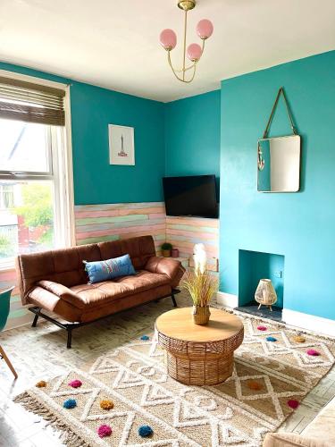 uma sala de estar com um sofá castanho e paredes azuis em Seaside Sundae Suite em Lytham St Annes