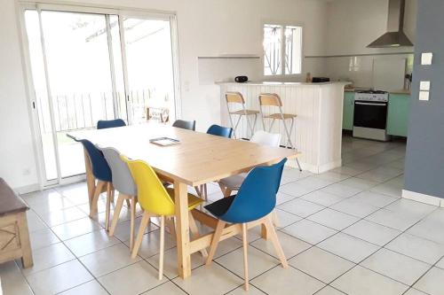 une cuisine avec une table et des chaises en bois dans l'établissement Paisible maison entre plages, lacs et bassin, à Le Porge