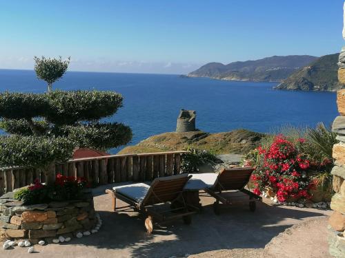 a patio with chairs and a view of the ocean at Logement de charme avec piscine privative in Pino