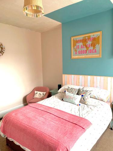 um quarto com uma cama grande e um cobertor rosa em Seaside Sundae Suite em Lytham St Annes