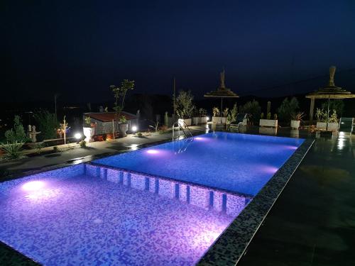 a swimming pool at night with purple lights at Maurice Bonjean in Ifrane