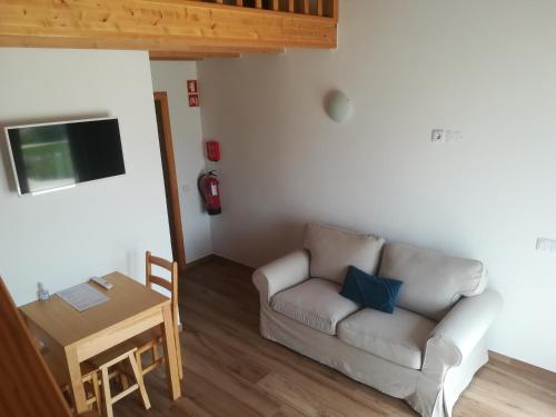 ein Wohnzimmer mit einem Sofa und einem Tisch in der Unterkunft Vila Lira in Aljezur
