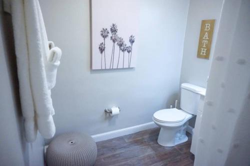 a bathroom with a toilet and a picture on the wall at The Beach House at Seascape Steps from the Beach, Marina and Shops! in West Palm Beach