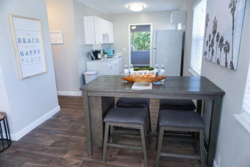a kitchen with a table and stools in a room at The Beach House at Seascape Steps from the Beach, Marina and Shops! in West Palm Beach