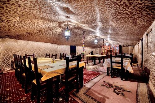 a dining room with a table and chairs and lights at Desert camp camel & sandboarding in Merzouga