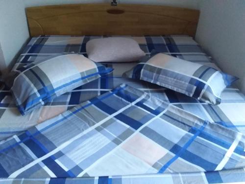 uma cama com lençóis e almofadas azuis e brancos em Tammaris Holiday Home em Visoko
