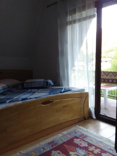 uma cama num quarto com uma grande janela em Tammaris Holiday Home em Visoko