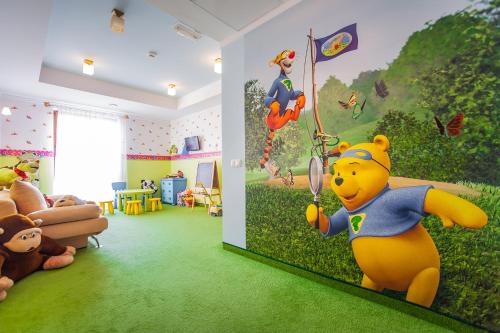 a room with a teddy bear and a wall mural of a winnie at SPA Hotel Splendor in Lubenia
