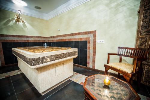 a bathroom with a tub and a chair and a candle at SPA Hotel Splendor in Lubenia