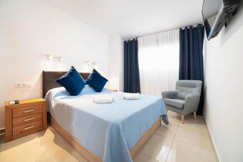 a bedroom with a blue bed and a chair at Cristina in Calpe