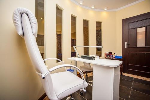 a dental chair in a dental office with a mirror at SPA Hotel Splendor in Lubenia