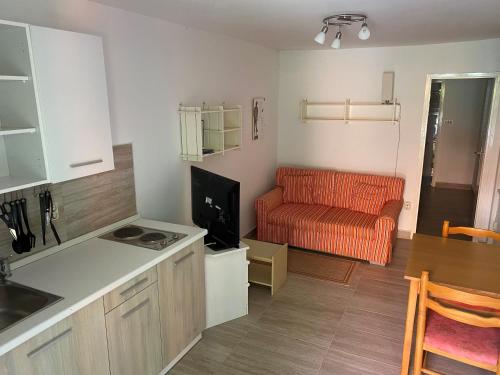 a kitchen and living room with an orange couch at Casita Liliana By the Sea in Mali Lošinj