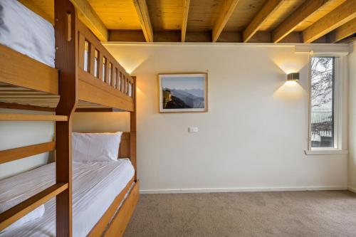 two bunk beds in a room with a window at Belltrees in Dinner Plain