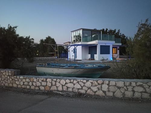 una piccola barca seduta di fronte a una casa di BlueTel Lixouri a Lixouri