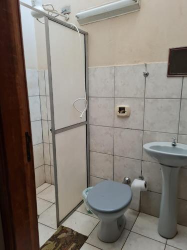 a bathroom with a toilet and a sink at Hotel Glória in Londrina